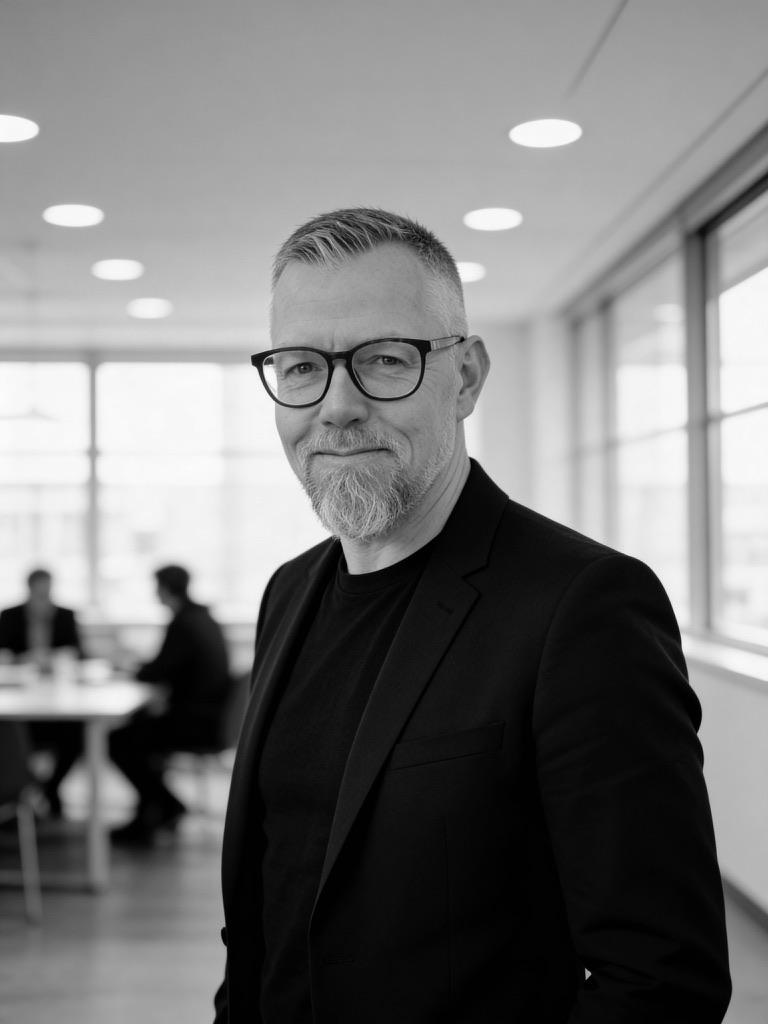 Black and white portrait of Daniel Kongstad Sebenius in a bright office.